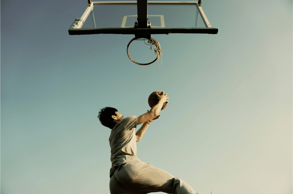 Basketball-Spieler wirft Korb, Himmel im Hintergrund. Revisionssichere Archivierung